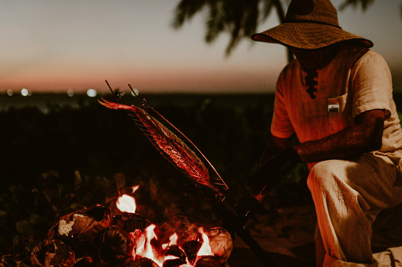 Fresh fish grilled over open fire on the beach